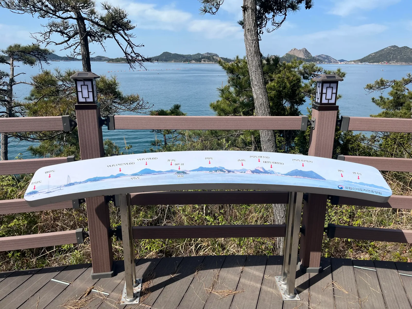 등받이에 주변 섬 그림과 섬 이름을 적은 전망 데크의 곡선 벤치