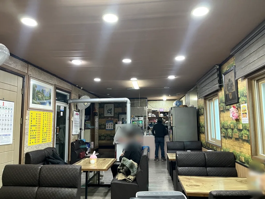 서천 장항 금희다방 내부 푹신한 소파와 벽면에 걸린 노란 메뉴판