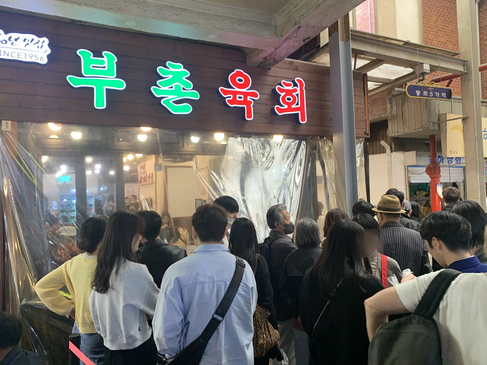 서울 종로 광장시장 육회 골목의 60년 전통 부촌육회 본점 간판과 대기 인파