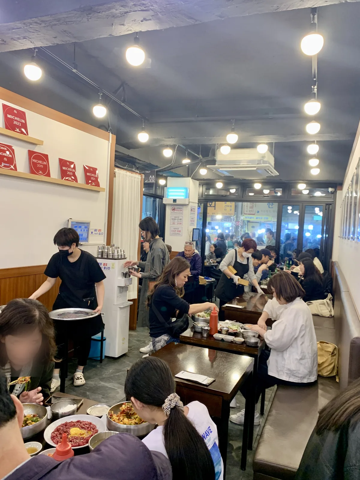 부촌육회 본점 실내 벽면에 나란히 걸린 미쉐린 가이드 서울 빕구르망 명판들