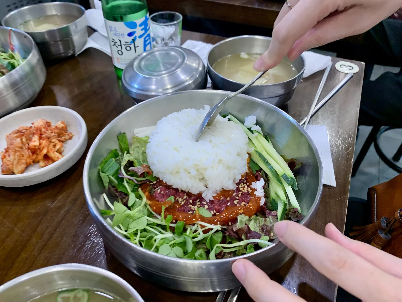부촌육회 테이블 위에 차려진 육회 한 접시와 맑은 청하 한 병의 정갈한 상차림